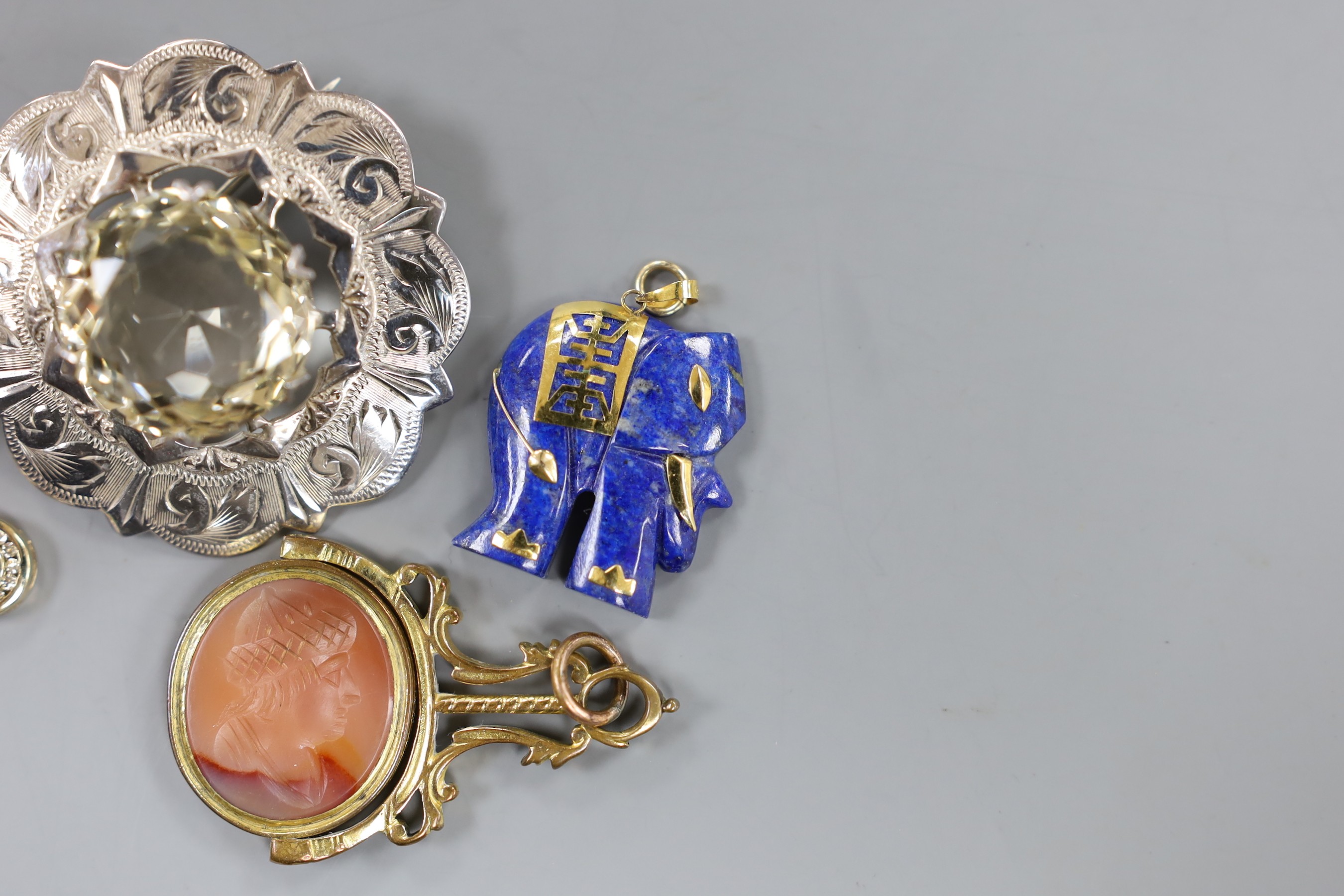 A modern yellow metal, ruby and diamond cluster set pear shaped pendant, overall 20mm, a Scottish silver mounted citrine brooch, a 9k mounted lapis lazuli elephant pendant, a 9ct dress ring, a gilt metal mounted and inta